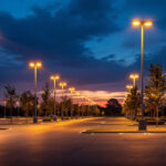 A photograph of a well-lit architectural parking lot at dusk