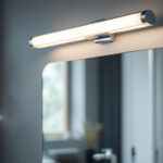 A photograph of a beautifully designed vanity light fixture installed above a stylish bathroom mirror