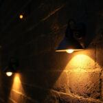 A photograph of a dimly lit outdoor space featuring a variety of outdoor house lights