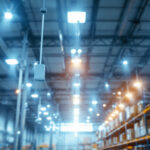 A photograph of a well-lit commercial warehouse interior showcasing various lighting fixtures in use