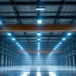 A photograph of a well-lit industrial space showcasing both high bay and low bay lighting fixtures in use