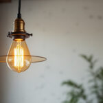 A photograph of a stylish industrial-style pendant light fixture hanging in a modern interior setting
