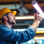 A photograph of a lighting contractor installing or showcasing fluorescent light bulbs in a commercial setting