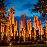A photograph of a beautifully lit outdoor flag display at dusk