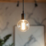 A photograph of a beautifully designed pendant light fixture hanging in a stylish interior setting