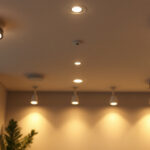 A photograph of a well-lit room featuring various types of recessed lighting fixtures
