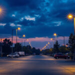 A photograph of a well-lit parking lot at dusk