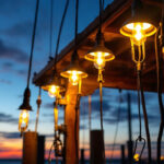 A photograph of a lighting contractor installing dock lights at dusk