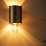 A photograph of a beautifully designed wall sconce illuminated in a stylish interior setting