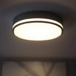 A photograph of a modern flat ceiling light fixture elegantly illuminated in a stylish interior setting