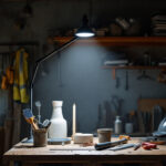 A photograph of a well-lit workspace featuring a solar shop light illuminating a contractor's tools and materials