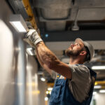 A photograph of a lighting contractor installing surface mount led lights in a modern commercial space
