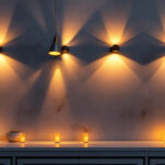 A photograph of a beautifully illuminated exterior wall featuring stylish lighting fixtures