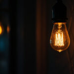 A photograph of a close-up of a flickering light bulb in a dimly lit setting