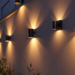 A photograph of a beautifully illuminated outdoor wall featuring a variety of stylish lighting fixtures