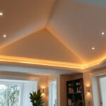 A photograph of a beautifully designed vaulted ceiling featuring recessed can lights