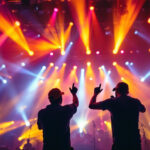 A photograph of a vibrant concert scene showcasing various popular light fixtures in action