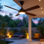 A photograph of a stylish outdoor ceiling fan with integrated lighting installed in a beautifully landscaped patio setting