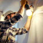 A photograph of a lighting contractor expertly installing replacement led lights in a modern residential setting