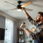 A photograph of a skilled lighting contractor installing a stylish ceiling fan in a modern living space