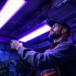 A photograph of a lighting contractor installing or demonstrating the use of ultraviolet lights in a garage setting