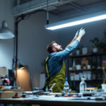 A photograph of a well-lit workspace featuring a 4-foot fluorescent light fixture in action