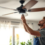 A photograph of a skilled lighting contractor demonstrating the installation of an overhead fan switch