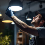 A photograph of a lighting contractor skillfully installing or adjusting modern lighting fixtures in a well-lit