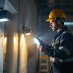 A photograph of a lighting contractor installing energy-efficient block flood lights in a commercial setting