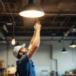 A photograph of a lighting contractor installing energy-efficient led fixtures in a commercial space