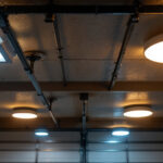 A photograph of a well-lit garage ceiling showcasing various types of ceiling lights