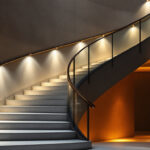 A photograph of a beautifully illuminated staircase featuring various lighting fixtures