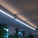 A photograph of a well-lit room featuring sleek led tube lights installed along the ceiling
