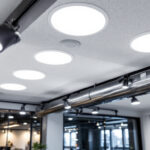 A photograph of a well-lit commercial space featuring recessed light fixtures installed in a suspended ceiling