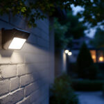 A photograph of a well-lit outdoor scene featuring a dusk-to-dawn security light with an integrated camera
