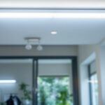 A photograph of a well-lit workspace featuring a 4' fluorescent two-bulb fixture installed in a ceiling