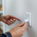 A photograph of a skilled lighting contractor installing a movement light switch in a modern home