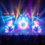 A photograph of a vibrant concert scene showcasing dynamic lighting fixtures in action
