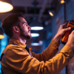 A photograph of a lighting contractor expertly installing or adjusting modern lighting fixtures in a well-lit commercial space