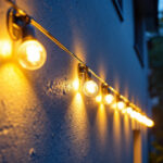 A photograph of a skilled lighting contractor meticulously installing a long run of led residential lights along a modern home’s exterior