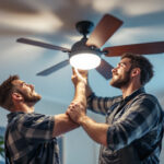 A photograph of a lighting contractor skillfully installing or adjusting a ceiling fan with integrated lighting features