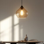 A photograph of a stylish dining area featuring a modern pendant light as the focal point
