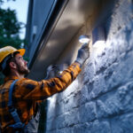 A photograph of a lighting contractor installing solar lights in a residential setting