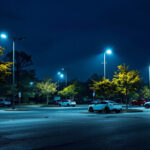A photograph of a well-lit parking lot at dusk