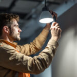 A photograph of a lighting contractor expertly installing a type t light in a well-lit space