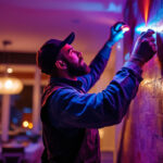A photograph of a lighting contractor skillfully installing keystone lights in a residential or commercial setting