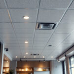 A photograph of a modern drop tile ceiling installation in a well-lit commercial space