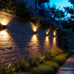 A photograph of a beautifully illuminated outdoor space featuring solar wall lights installed on a garden wall