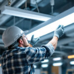 A photograph of a lighting contractor expertly installing t8 led fixtures in a commercial space