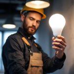 A photograph of a lighting contractor installing or showcasing a t5 led bulb in a modern